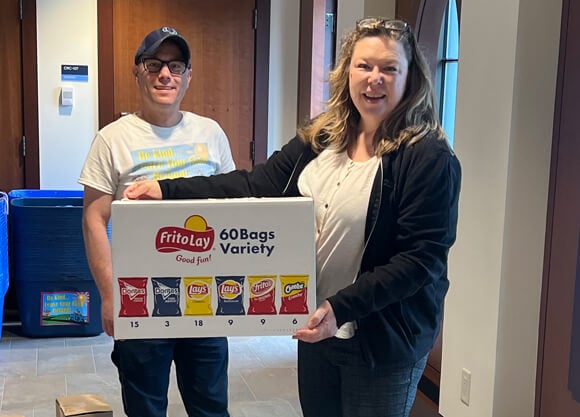 Two people holding a box of food