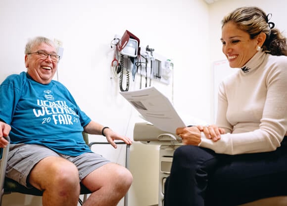 Two people sitting in a room and smiling