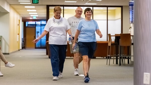 Three adults wearing comfortable clothes walk inside for the Bobcat Stride program