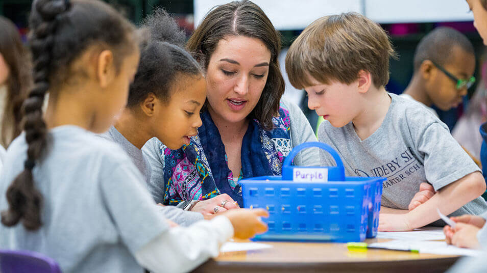 A School of Education student plays a board game with elementary school students